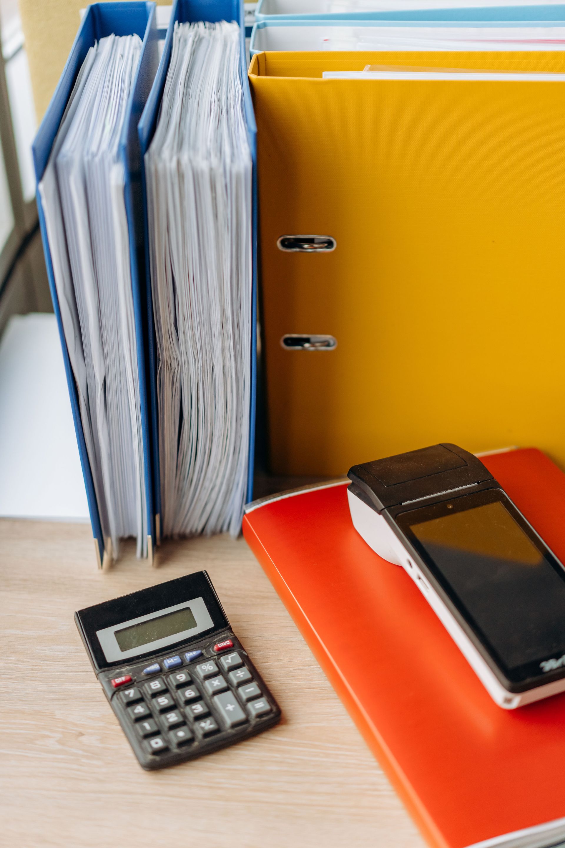 Organized office desk with a calculator, files, and documents for efficient work.